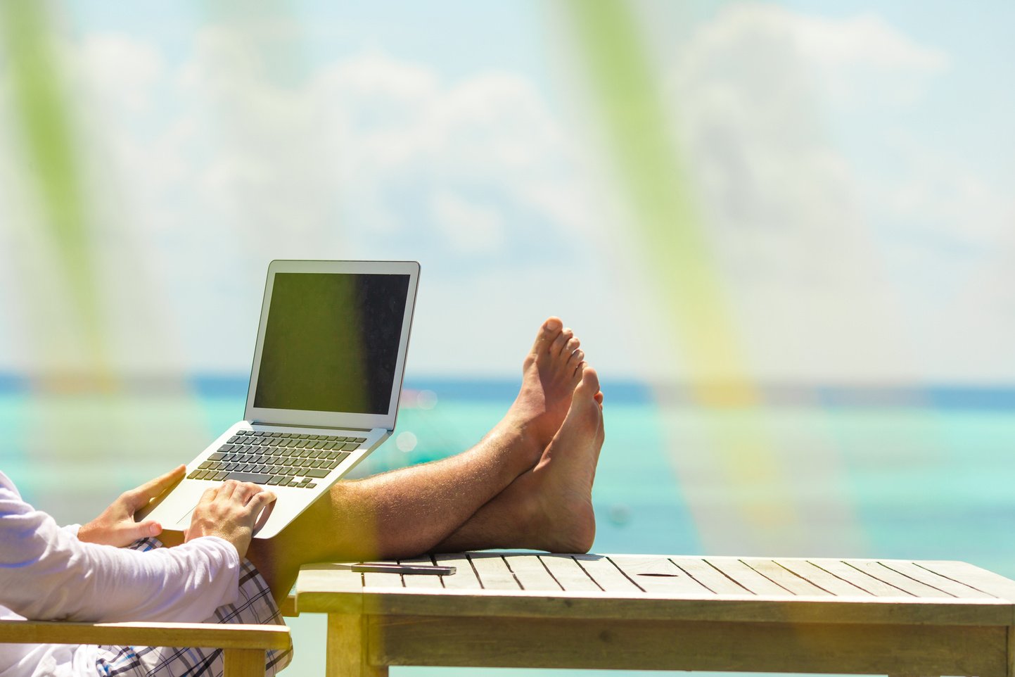 Young Man with Computer during Tropical Beach Vacation